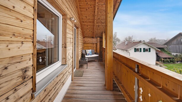 Una terraza de madera con vistas a casas vecinas.