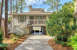 A two-story house with a covered front porch, a staircase, and a driveway leading to a garage.