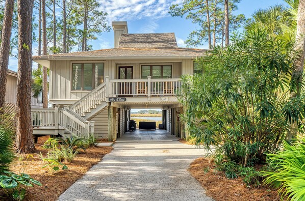 A two-story house with a covered front porch, a staircase, and a driveway leading to a garage.