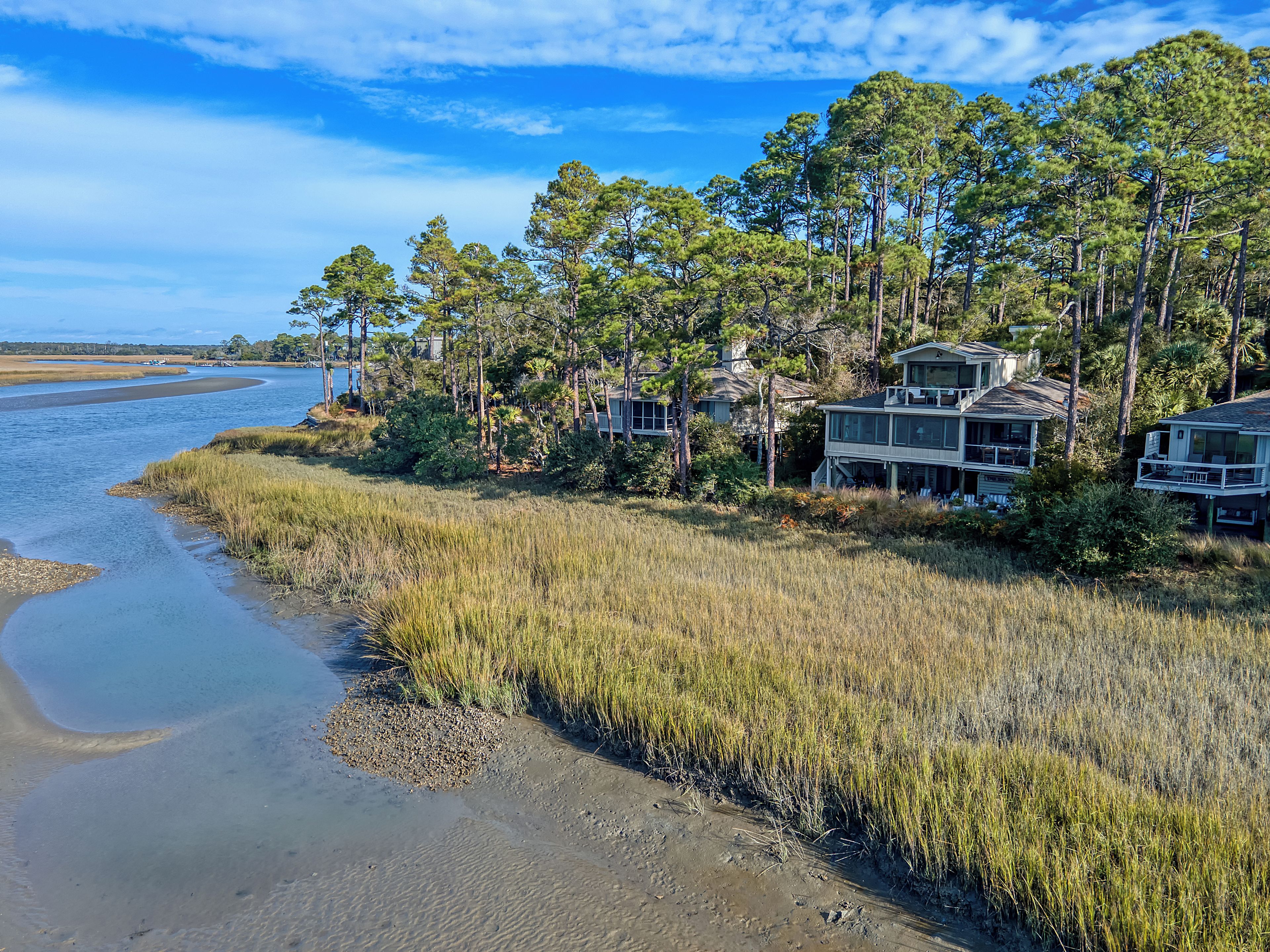 A coastal property with multiple houses, a river, and surrounding vegetation.