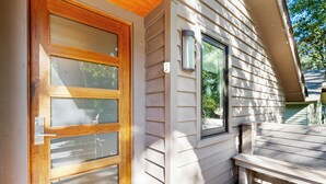 A wooden door with glass panels, a small window with a light fixture, and a wooden bench outside a house. - Yards to the beach, stunning new reno (Kiawah Island)