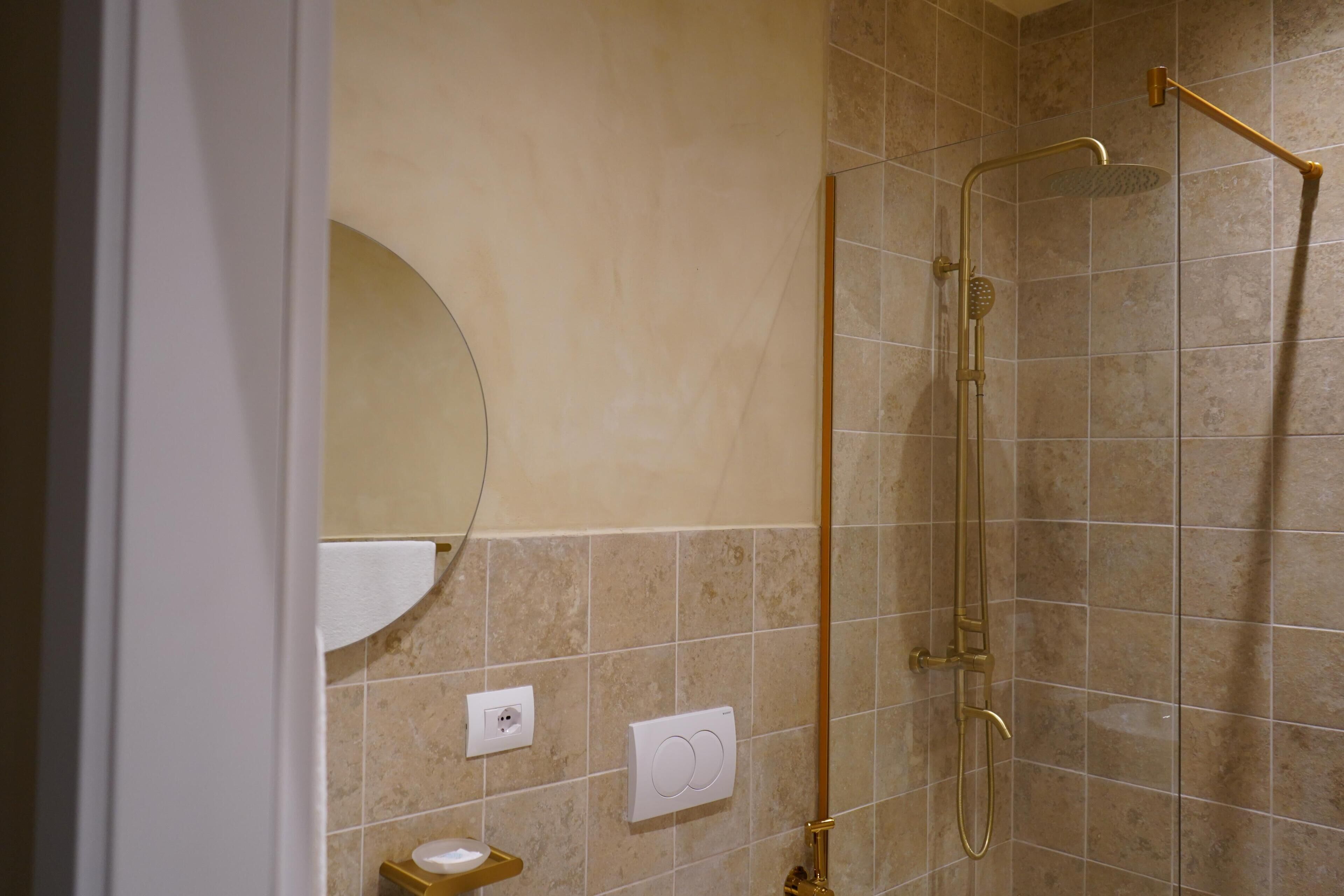 A bathroom with a shower, a toilet, and a sink.
