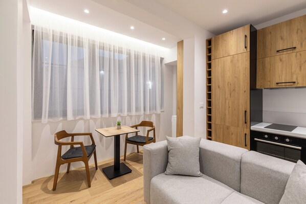 Standard Apartment 102, Kitchen | Living area | 50-cm Smart TV with digital channels, fireplace - Vatër Apartments (Tirana)