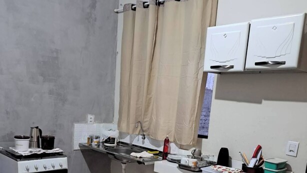 Une cuisine de taille réduite, équipée d’une cuisinière, d’un évier et d’un petit plan de travail.
