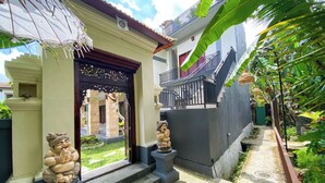 A residential building with a traditional entrance, a staircase, and a small garden area. - Oemah Surya Ubud (Ubud)
