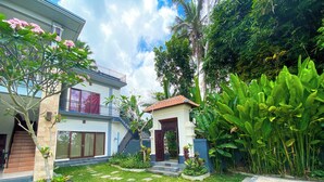 A residential property with a two-story house, a small garden with stepping stones, and lush greenery. - Oemah Surya Ubud (Ubud)