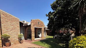 A residential property with a brick exterior, a paved driveway, and a well-maintained lawn. - Mosele wa Pula Guesthouse  (Rustenburg)