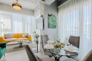Relax in this stylish living room with a dining table for four, a sofa, and an armchair.