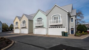 A row of three-story houses with attached garages, a clear driveway, and a well-maintained lawn. - 4 BR, 4.5 BA Townhouse- Park & Walk to shops, eateries & beach in Rehoboth. (Rehoboth Beach)