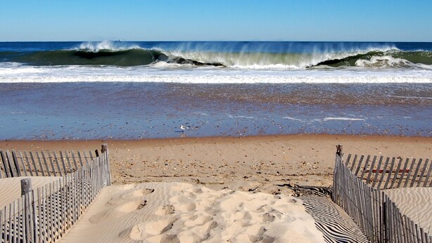 A beach with waves, a wooden fence, and a sandy shore. - 4 BR, 4.5 BA Townhouse- Park & Walk to shops, eateries & beach in Rehoboth. (Rehoboth Beach)