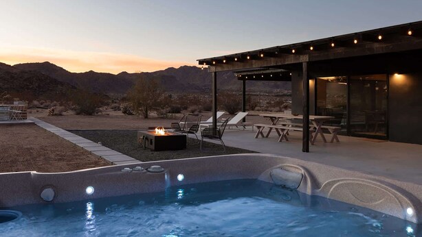 Un bain à remous avec foyer intégré, un espace salon extérieur et une vue sur les montagnes.