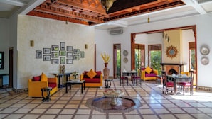 A spacious lobby with a high ceiling, patterned floor, and a central seating area with sofas and chairs. - Palais Volteras (Marrakech)