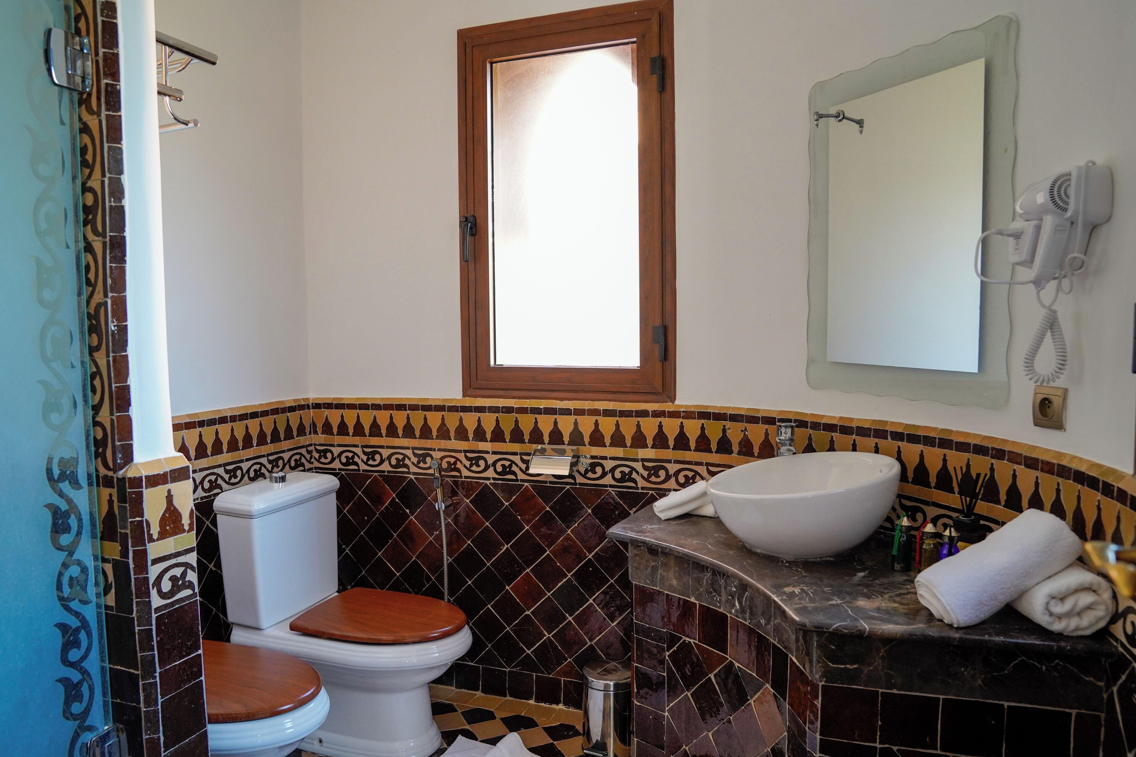 Een badkamer met toilet, wastafel en spiegel.