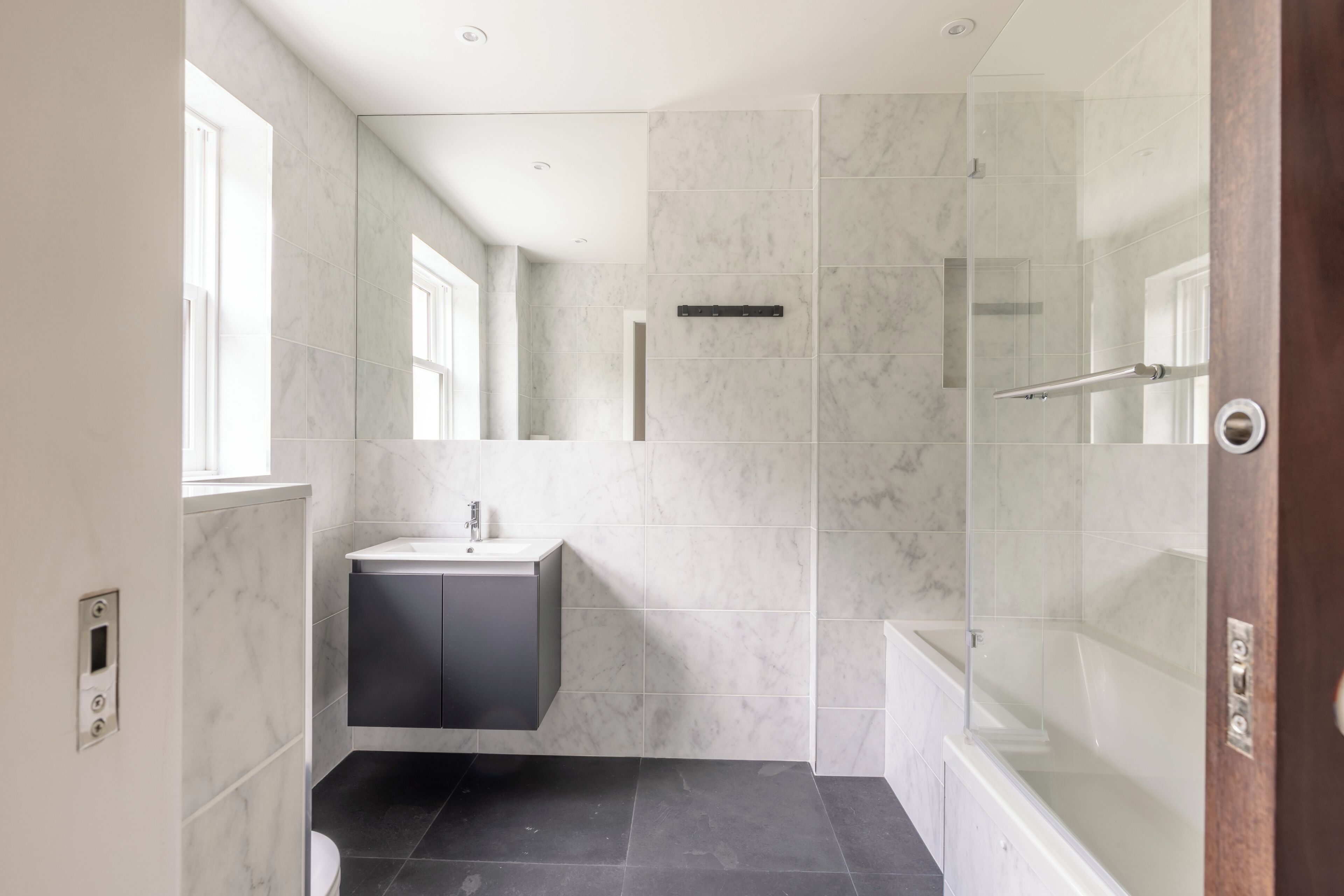 A modern bathroom with a shower, a sink, and a toilet.