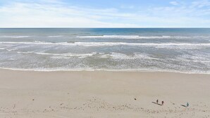 A beach with waves and a clear sky.