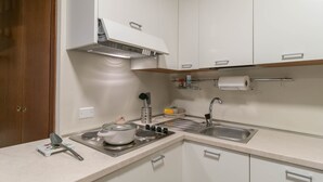 A kitchen with white cabinets, a stainless steel sink, and a built-in stove. - A Due Passi dal Lago (Tremezzina)