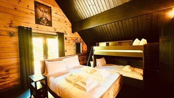 Een gezellig houten slaapkamer met een stapelbed, een nachtkastje en een raam met gordijnen.