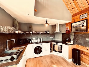 Una cocina moderna con lavadora integrada, estufa y lavaplatos.