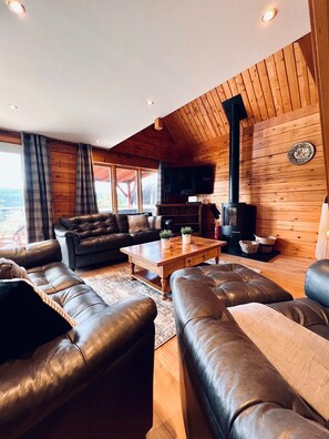 Un salon chaleureux avec des canapés en cuir, une table basse en bois et une cheminée.