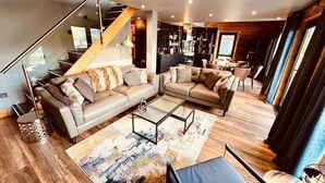 Una sala de estar moderna con un sofá modular grande, una mesa de centro y una escalera.