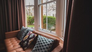 Ein Fensterplatz mit Blick auf Gebäude und Grünflächen.