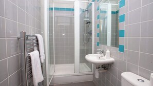 A modern bathroom with a glass shower enclosure, a white sink, and a towel rack. - Stunning City Centre Duplex (Glasgow City)
