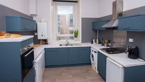 Una cocina compacta con horno empotrado, lavadora y estufa.