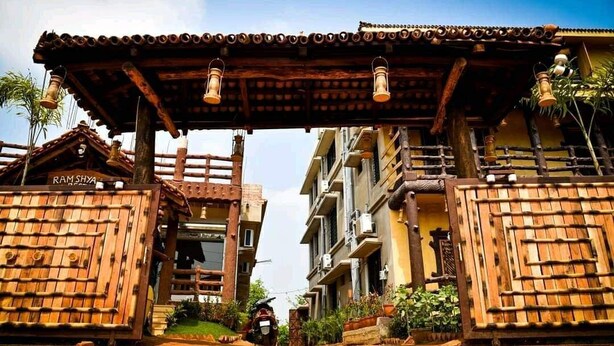 A traditional wooden gate with a sign reading "RAM SHYA" and a scooter parked nearby. - Khoai Village Resort (Bolpur)