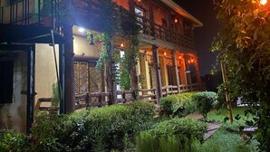 A two-story building with a balcony, wooden railings, and hanging lanterns. - Khoai Village Resort (Bolpur)