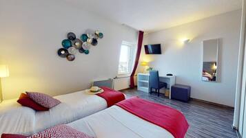 Habitación de hotel con dos camas, un escritorio, una silla, un televisor y un espejo.