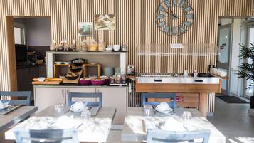 A modern dining area with a wooden panel wall, a clock, and a buffet counter.