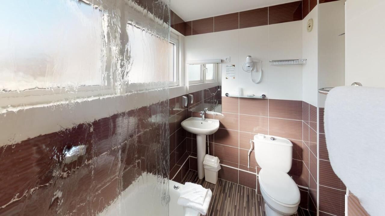 Un baño con bañera, lavamanos e inodoro.
