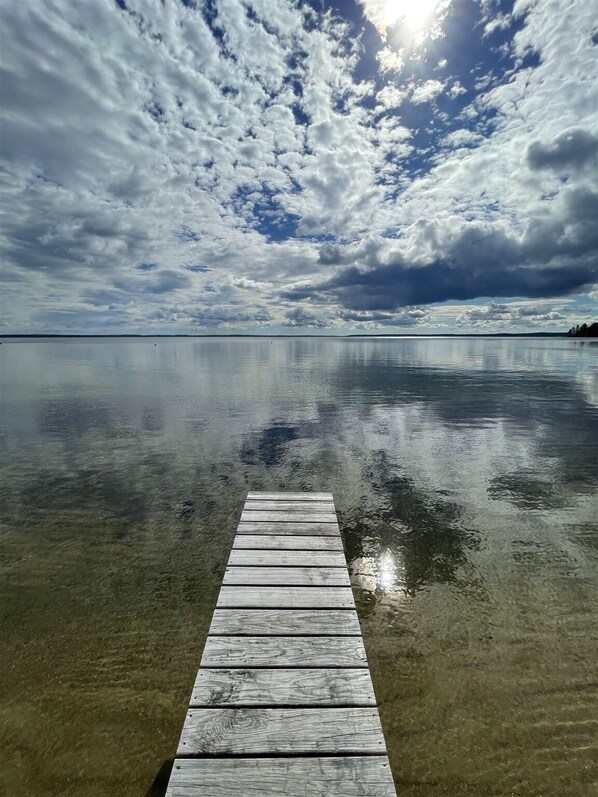A wooden pier extending into calm water under a partly cloudy sky. - RUSTIC LAKESIDE COTTAGE. LARGE SANDY BEACH (Sebago)