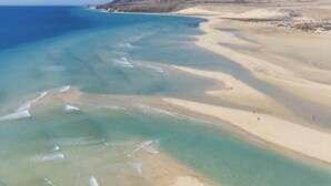 An aerial view of a beach with clear waters and sandy shores. - Villa Majanicho with pool (Majanicho)