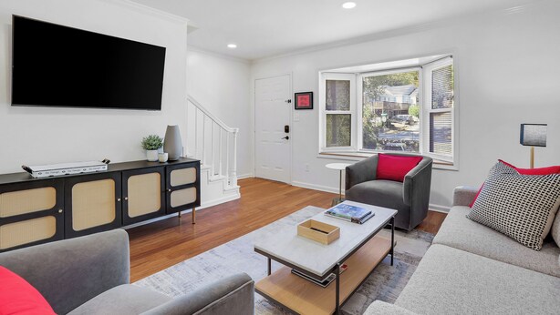 A modern living room with a flat-screen TV, a console table, and a sofa. - 0.5 mi UGA Stadium & Campus– 2 BR 2.5 BA Athens Townhome with King, Queen + Twin (Athens)