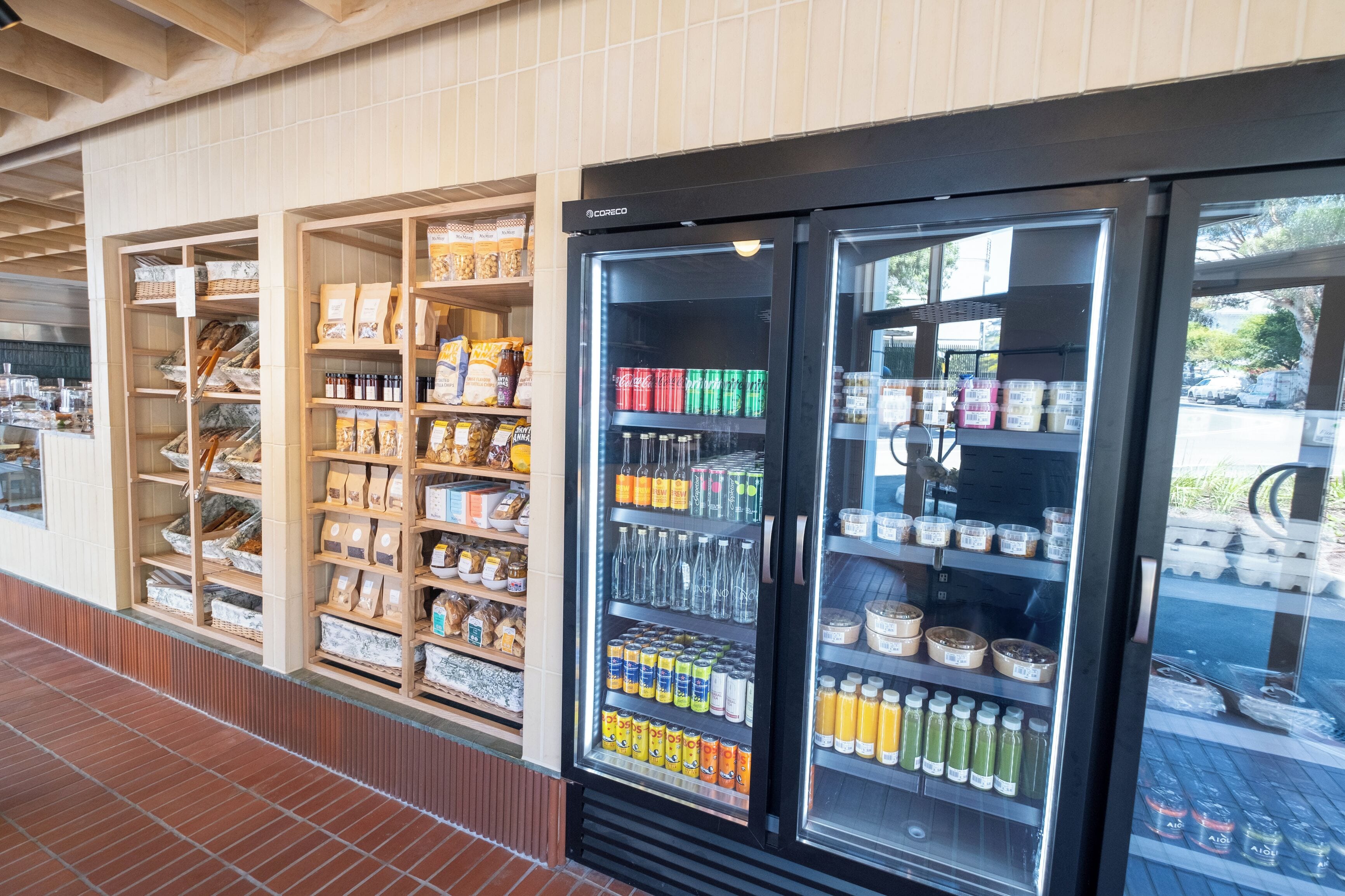 Een gekoelde vitrine met verschillende drankjes en verpakte producten.