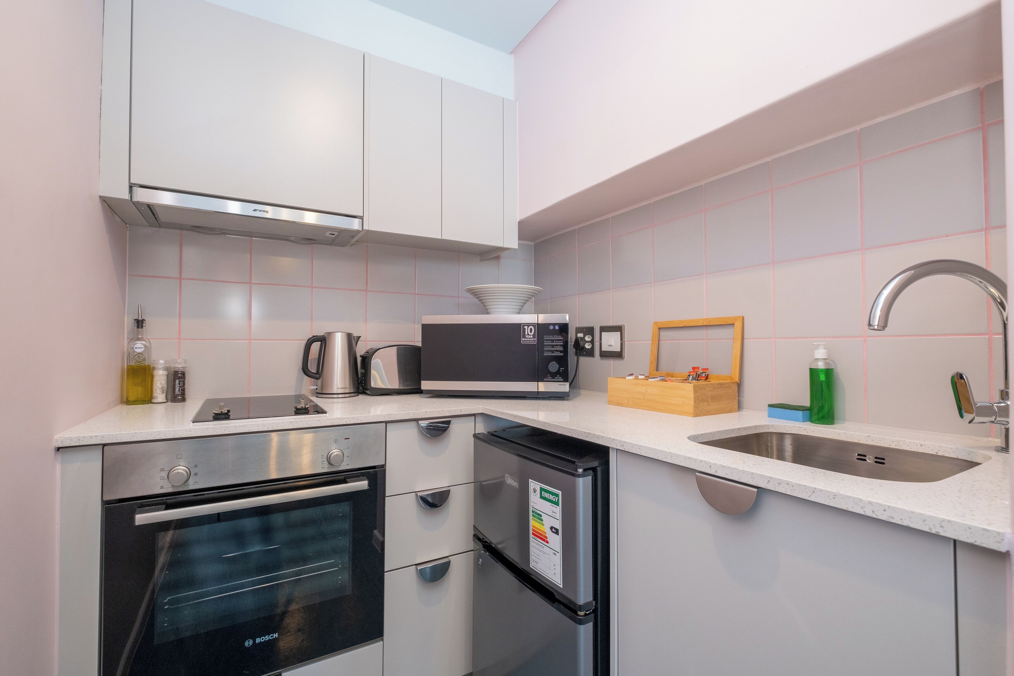 A modern kitchen with stainless steel appliances, a built-in oven, microwave, and dishwasher, and a sink with a faucet.