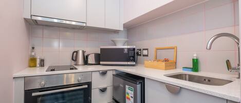 A modern kitchen with stainless steel appliances, a built-in oven, microwave, and dishwasher, and a sink with a faucet.