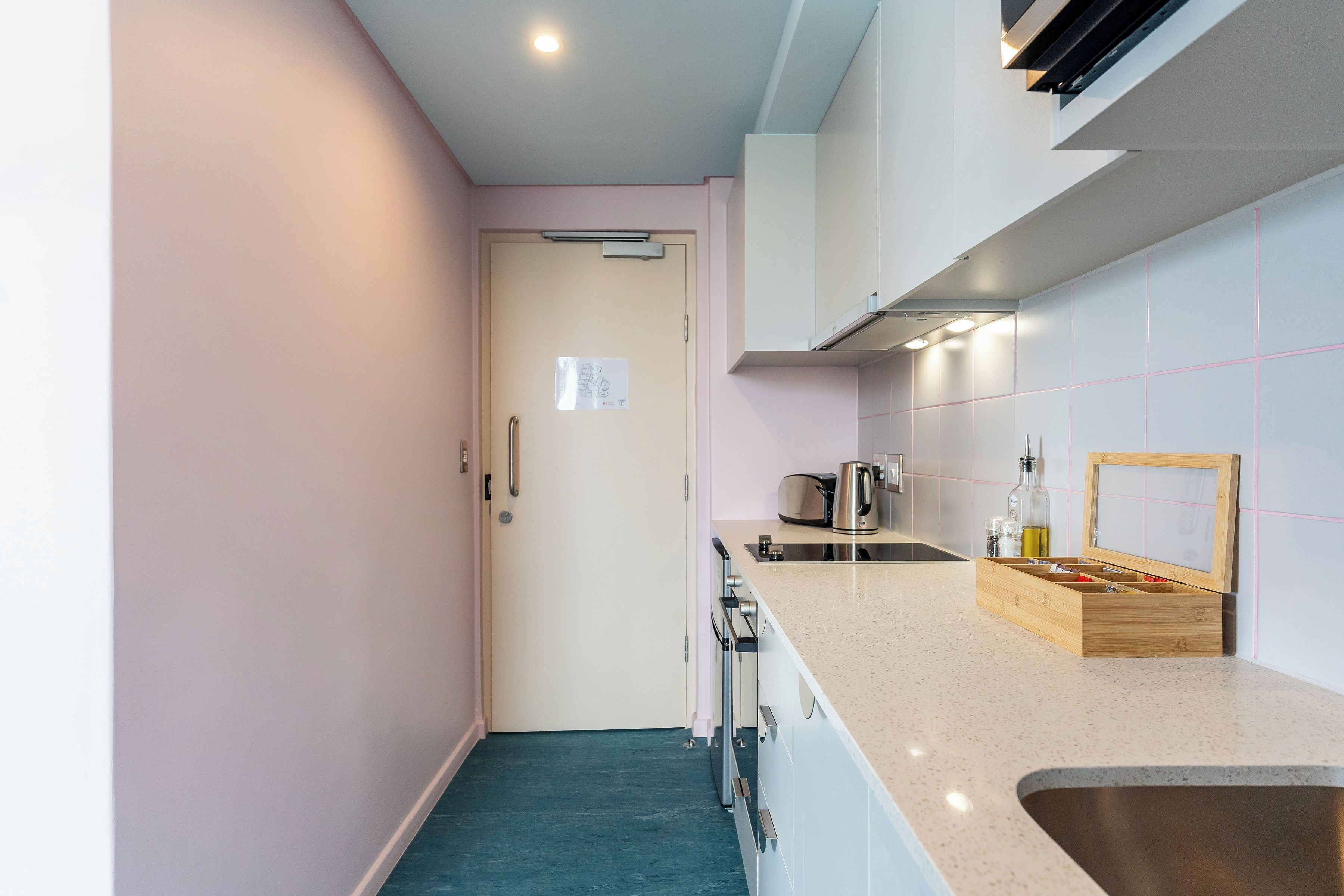 A modern kitchen with a stainless steel sink, a wooden countertop, and a built-in oven.
