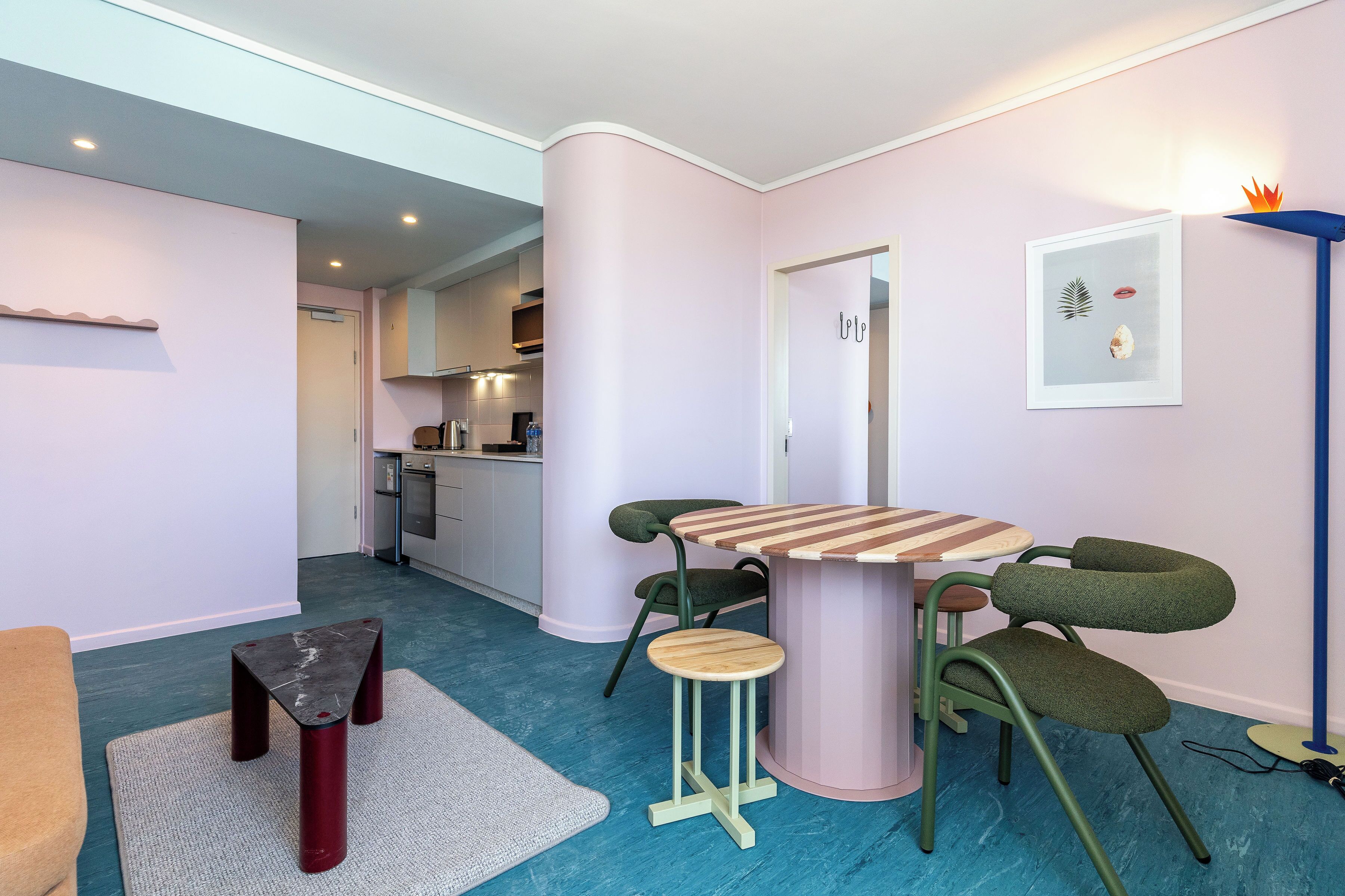 Une cuisine moderne avec un coin repas, comprenant une table ronde avec des chaises et un tabouret.