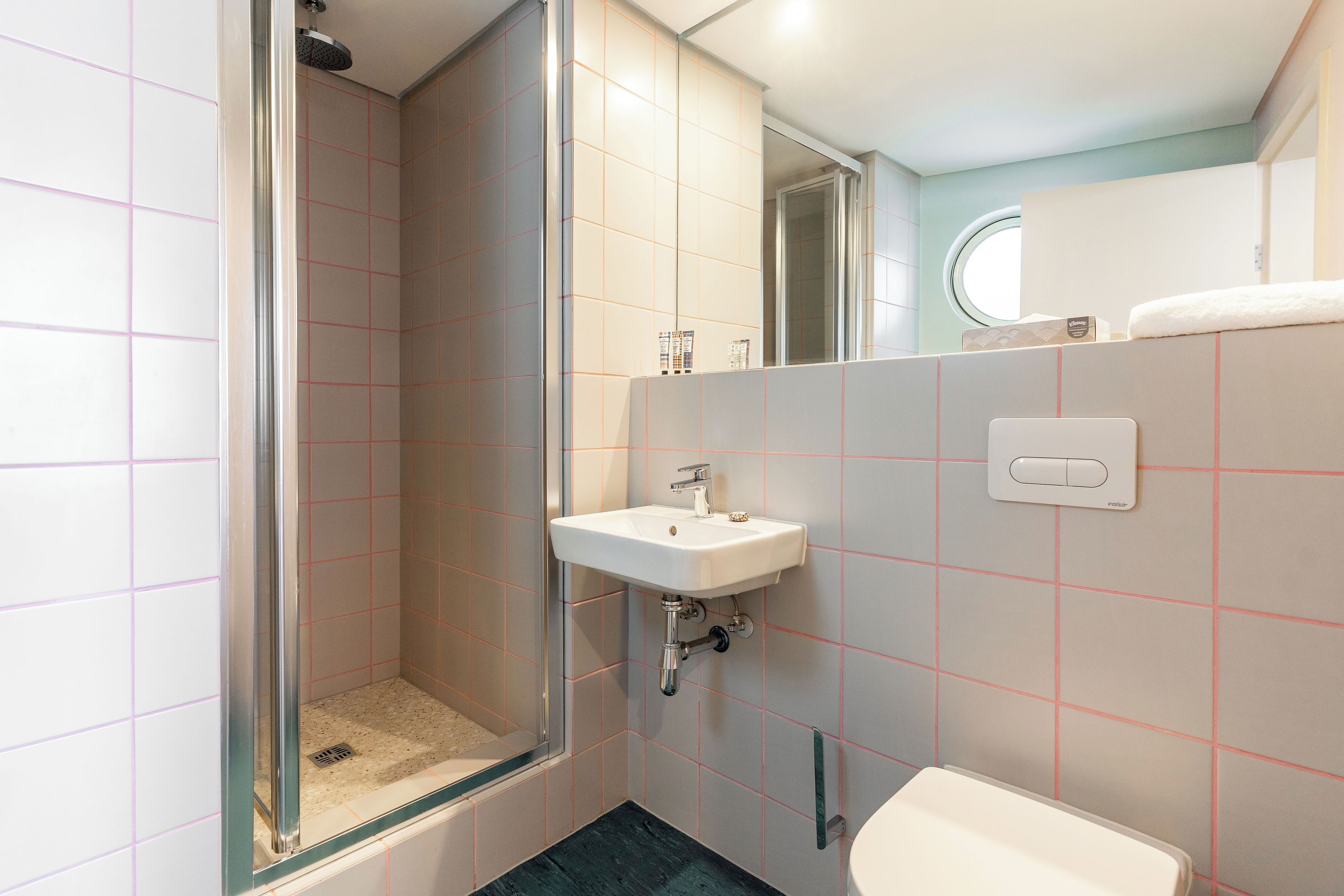 A bathroom with a shower, sink, and toilet.