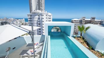 Una piscina al aire libre, sillones reclinables de piscina