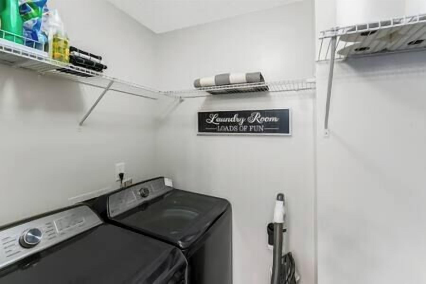 A laundry room with a sign that reads "Laundry Room Loads of Fun."