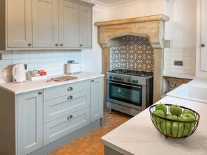 A kitchen with light blue cabinets, a gas stove, an oven, a toaster, and a fruit basket. - 2 bedroom accommodation in Barnard Castle (Barnard Castle)