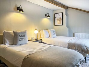 A bedroom with two beds, each with a pillow that reads "STAY COSY," a bedside table with a lamp, and a framed picture on the wall. - 2 bedroom accommodation in Barnard Castle (Barnard Castle)