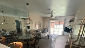 A spacious living area with a dining table, chairs, a sofa, and a TV. - Charming 2-bedroom condo in serene Lake Suzy with WiFi, AC (Lake Suzy)