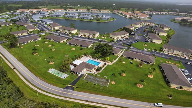 An aerial view of a residential community with multiple buildings, roads, and a lake. - Charming 2-bedroom condo in serene Lake Suzy with WiFi, AC (Lake Suzy)