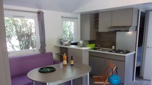 Una cocina compacta con comedor, un sofá y una silla.