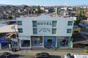 Un hotel con un letrero llamativo, entrada a nivel de calle y vista a la vía pública.