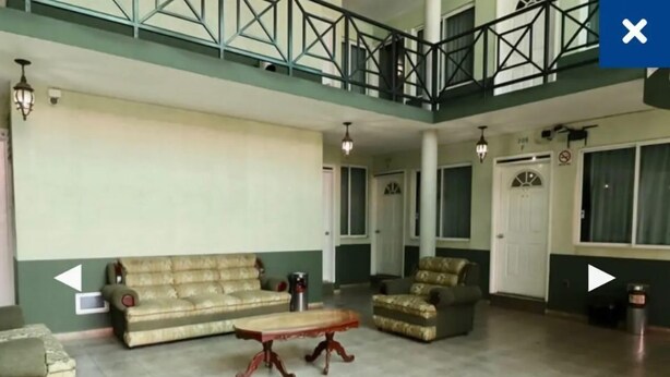 A spacious living room with a sofa, armchair, and coffee table. - Hotel Real Santa Rosa (Morelia)